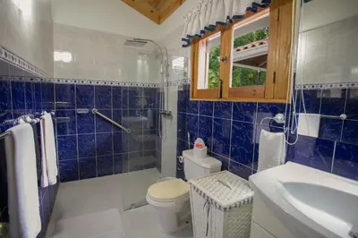 a blue tiled bathroom with a toilet and a sink at Fontana di Rosa, African Style Villa Casa de Campo in La Romana