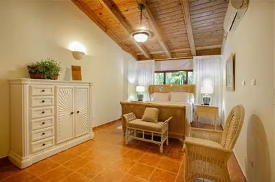 a bedroom with a bed and a desk and a chair at Fontana di Rosa, African Style Villa Casa de Campo in La Romana