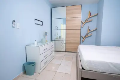 a bedroom with a white bed and a dresser at Suite 10 en la Zona Colonial in Santo Domingo