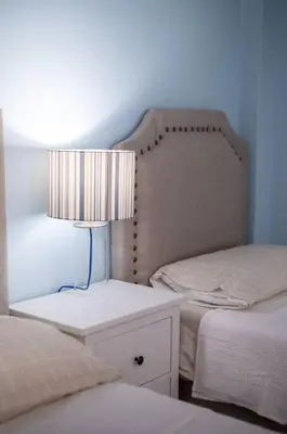 a bedroom with two beds and a lamp on a night stand at Suite 10 en la Zona Colonial in Santo Domingo