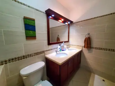 a bathroom with a toilet and a sink and a mirror at Casa Linda beautiful Villa in Sosúa