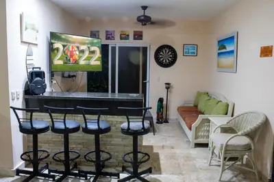 a living room with a bar with stools at Casa Linda beautiful Villa in Sosúa