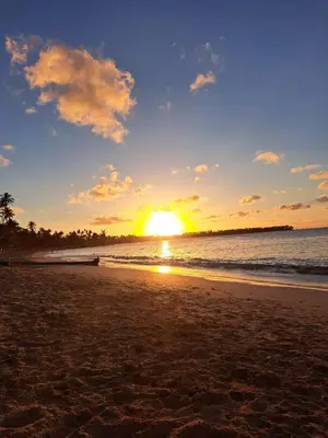 a sunset on a beach with the ocean at Casita Chinola - Playa El Encuentro in Bombita