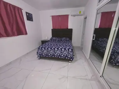 a bedroom with a bed and a mirror in it at Apartamento amueblado Res Blue Amber, 1 habitación in Santiago de los Caballeros