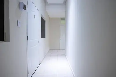 a hallway with white walls and a white tile floor at Cozy Suite 8 en la Zona Colonial in Santo Domingo