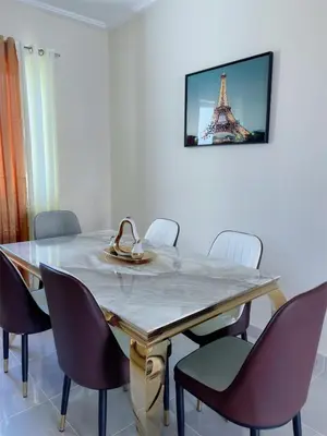 a dining room table with chairs and a picture of the eiffel tower at Sunset Home 2B (Gated) in Higuey