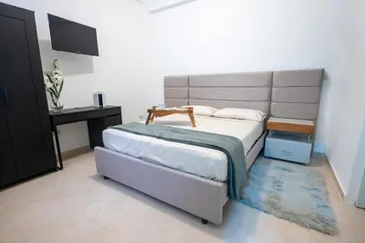 a bedroom with a bed and a desk and a television at Estudio 9 en la Zona Colonial in Santo Domingo