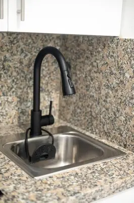 a kitchen sink with a black faucet at Estudio 9 en la Zona Colonial in Santo Domingo