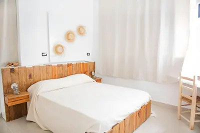 a bedroom with a wooden bed and a window at Hostal Mamà Mambò - Zona Colonial in Santo Domingo
