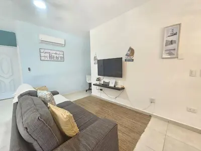 a living room with a couch and a flat screen tv at Private Pool View 2BDR in Los Corales Punta Cana in Punta Cana