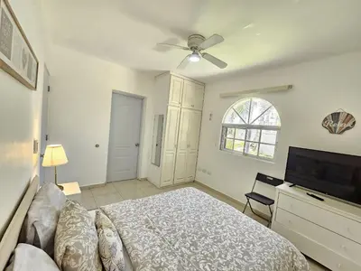 a bedroom with a bed and a flat screen tv at Private Pool View 2BDR in Los Corales Punta Cana in Punta Cana