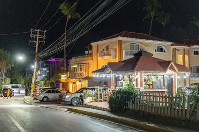 a building with a store on the side of a street at night at Private Pool View 2BDR in Los Corales Punta Cana in Punta Cana
