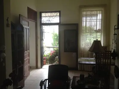 a living room with a door and a table and a chair at Centerpice Colonial Zone in Santo Domingo