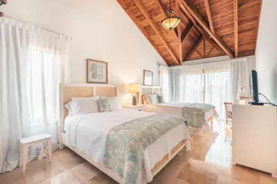 a bedroom with two beds and a television in it at Magnificent Villa at Puerto Bahia in Sabana