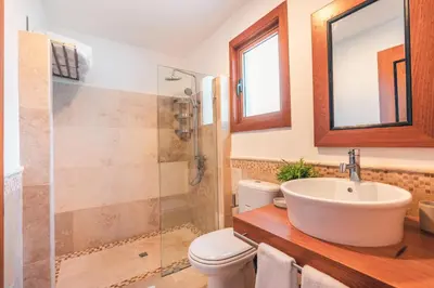 a bathroom with a toilet and a sink and a shower at Magnificent Villa at Puerto Bahia in Sabana