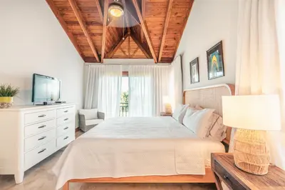 a bedroom with a large bed and a television at Magnificent Villa at Puerto Bahia in Sabana
