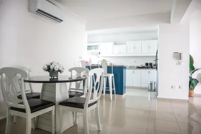 a kitchen and dining room with a table and chairs at Salt Air & City Vibe Awaits! Just Minutes to Beach in San Felipe de Puerto Plata