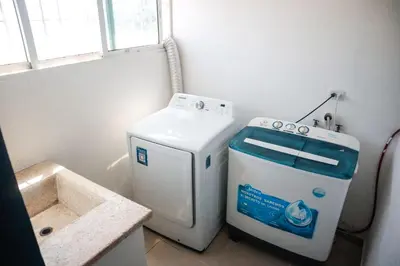 a washer and dryer in a bathroom with a sink at Salt Air & City Vibe Awaits! Just Minutes to Beach in San Felipe de Puerto Plata