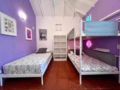 two bunk beds in a room with purple walls at PETRAKl HOMES in Las Galeras