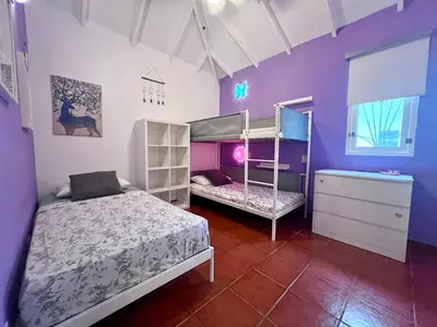 a bedroom with two bunk beds and purple walls at PETRAKl HOMES in Las Galeras
