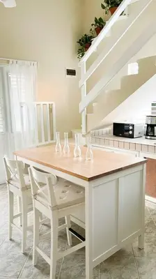 a kitchen with a table with chairs and a staircase at Casa Alegria Beach Cottage in Las Terrenas