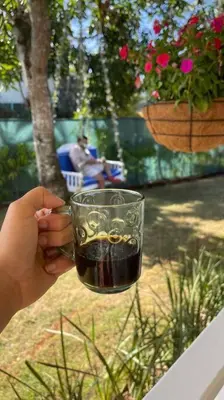 a person holding a glass of drink on a table at Casa Alegria Beach Cottage in Las Terrenas
