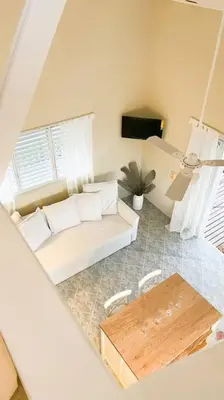 a living room with a white couch and a table at Casa Alegria Beach Cottage in Las Terrenas
