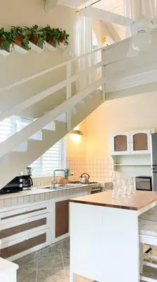 a kitchen with a white staircase in a kitchen at Casa Alegria Beach Cottage in Las Terrenas