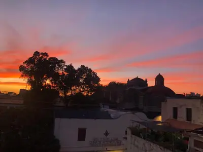 a sunset over a city with buildings and trees at Centrico ciudad colonial in Santo Domingo