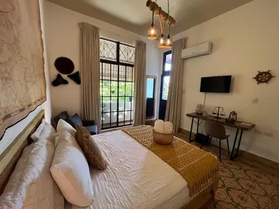 a bedroom with a bed and a desk and a window at Studio 27 Colonial, Centro Histórico in Santo Domingo