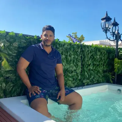 a man sitting in a swimming pool at Studio 27 Colonial, Centro Histórico in Santo Domingo