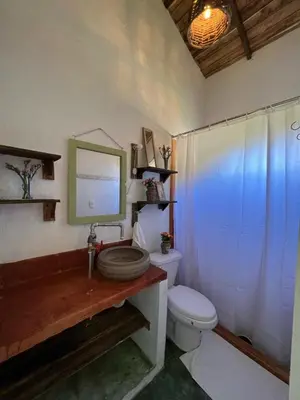 a bathroom with a toilet and a sink with a mirror at La Casita de Charo 2, vive y siente el amor, creando recuerdos de vida!! in Constanza
