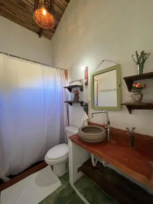 a bathroom with a toilet and a sink and a mirror at La Casita de Charo 2, vive y siente el amor, creando recuerdos de vida!! in Constanza