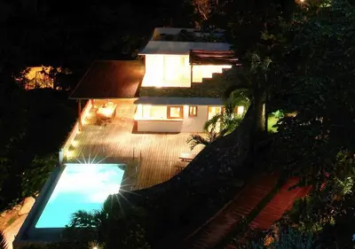 a house with a swimming pool in front of it at night at Propiedad de alto standing con vista al mar, piscina, tenis, hasta 12 personas in Las Terrenas