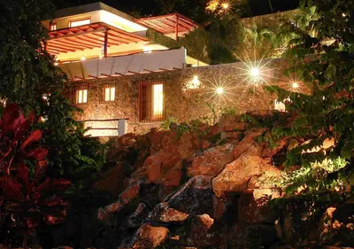 a stone house at night with lights at Propiedad de alto standing con vista al mar, piscina, tenis, hasta 12 personas in Las Terrenas