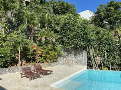 a pool with two chairs and a bench next to it at Propiedad de alto standing con vista al mar, piscina, tenis, hasta 12 personas in Las Terrenas