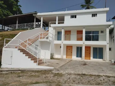 a white house with a staircase in front of it at Samaná Suites Hotel by Habita in Santa Bárbara de Samaná