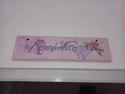 a sign on top of a fireplace with flowers on it at Doña Mayra Aparta Hotel in Las Terrenas