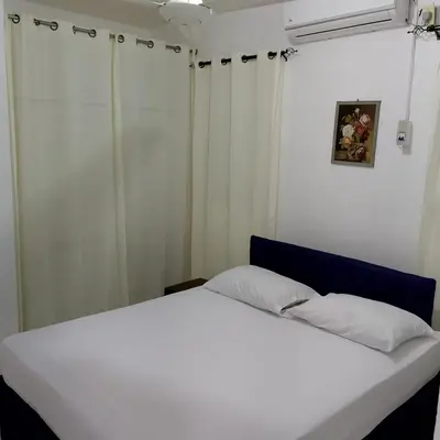 a white bed in a room with white curtains at Hotel Ningo in Santa Bárbara de Samaná