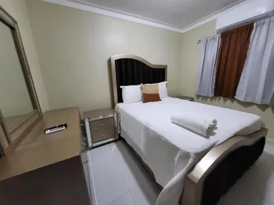 a bedroom with a large bed with white sheets at Hermoso y comodo apartamento in Santiago de los Caballeros
