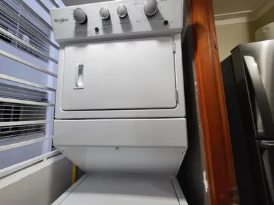 a white stove in a kitchen next to a refrigerator at Hermoso y comodo apartamento in Santiago de los Caballeros