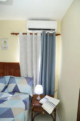 a bedroom with a bed and a table with a lamp at Apto CALETA BEACH 3HAB in La Romana