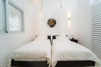 two beds in a bedroom with white walls and windows at Casa Panamera- 5br luxury beach Villa Playa Coson in Las Terrenas