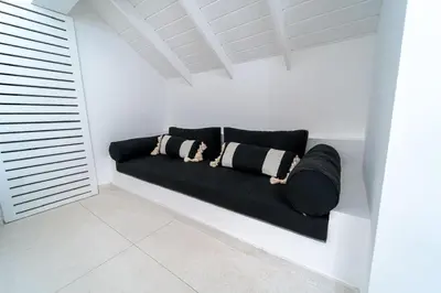 a black couch in a white room with pillows at Casa Panamera- 5br luxury beach Villa Playa Coson in Las Terrenas