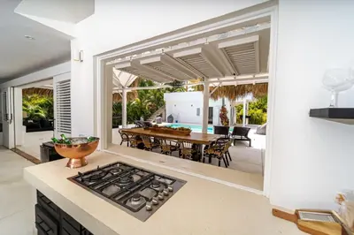 a kitchen and dining room with a table and a stove at Casa Panamera- 5br luxury beach Villa Playa Coson in Las Terrenas