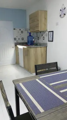 a kitchen with a table and chairs in a room at Apartamento Amueblado Caribe, Santo Domingo a 10 minutos del Aeropuerto Internacional de las Americas in Santo Domingo