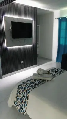 a living room with a flat screen tv on a wall at Apartamento Amueblado Caribe, Santo Domingo a 10 minutos del Aeropuerto Internacional de las Americas in Santo Domingo