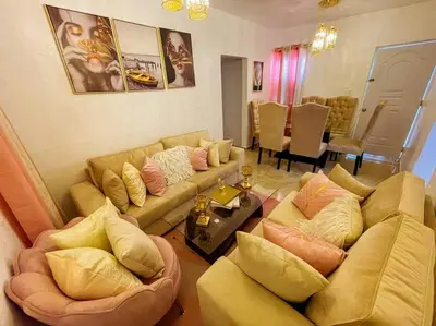a living room with two couches and a dining room at Acogedora casa de 2 habitaciones in Villa Isabela