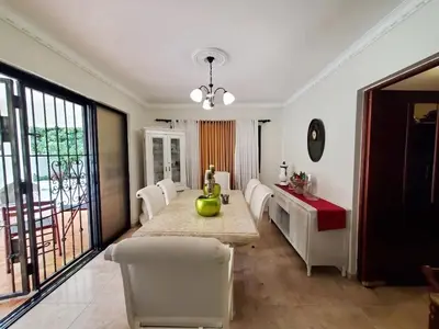 a dining room with a table and white chairs at Villa Isabel, NO SMOKING, cerca embajada USA in Santo Domingo