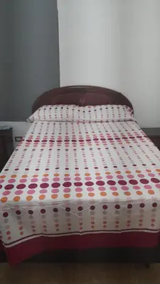 a bed with a polka dot sheets on it at Villa Isabel, NO SMOKING, cerca embajada USA in Santo Domingo